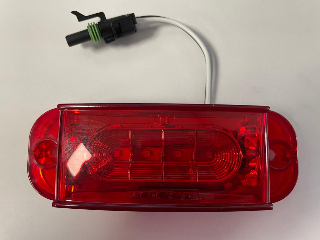 Red LED trailer tail light with wiring connector on white background