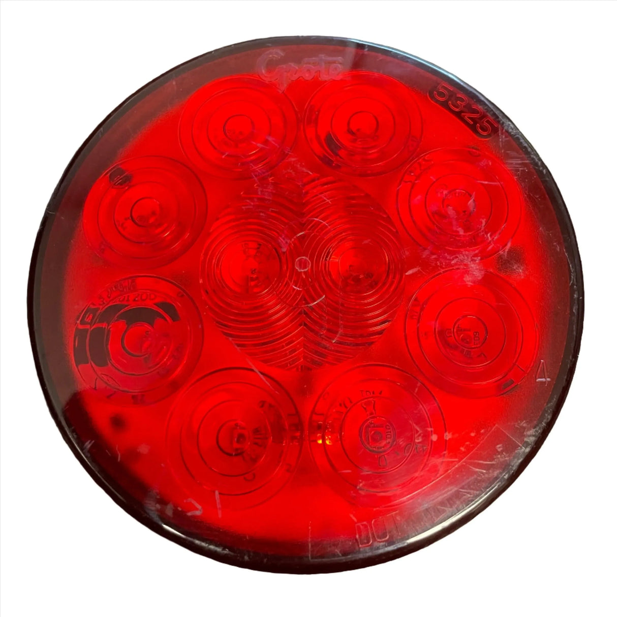 Round red Grote 5325 LED trailer tail light with visible lens scratches