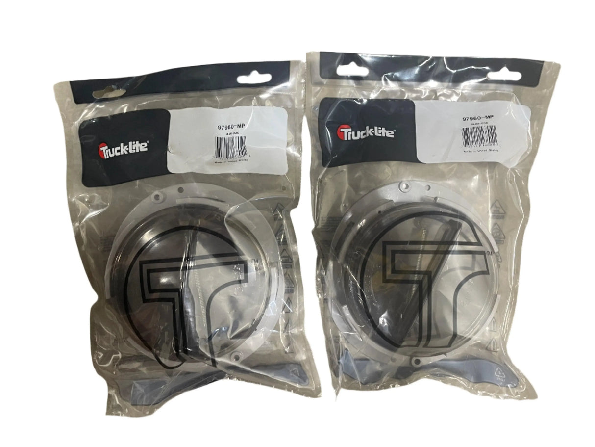 Two packaged Truck-Lite 97960-MP round metal automotive parts on white background