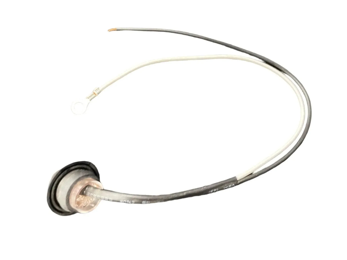 Round metal automotive sensor with black and white attached wires on white background