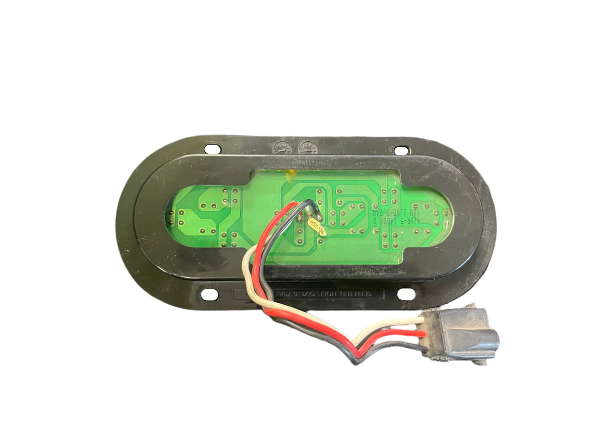 Oval green LED circuit board with wires and connector on a black mounting plate