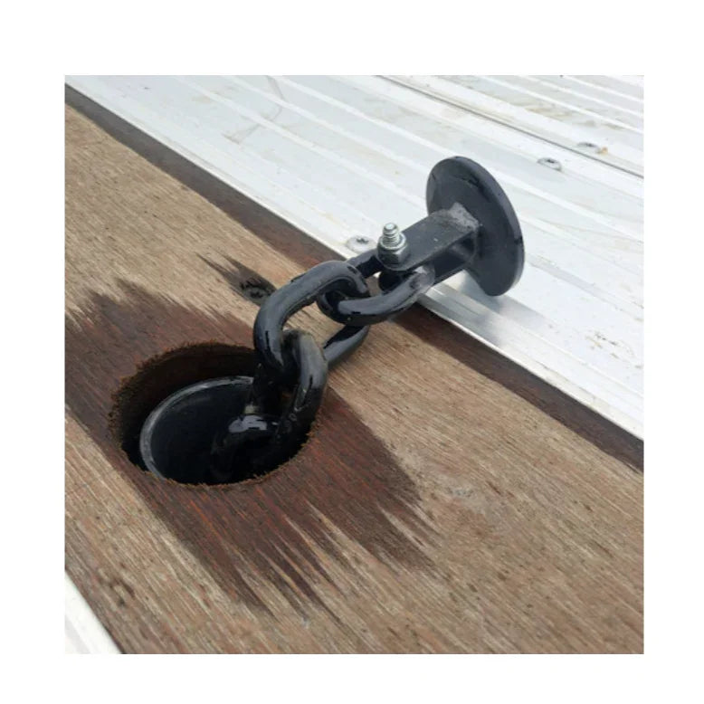 Steel trailer stake pocket D-ring anchor with chain on wood and metal trailer bed