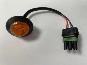 Amber LED marker light with black mounting grommet and three-wire connector on white background