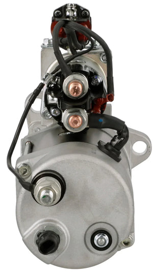 Close-up of a silver automotive starter motor with electrical terminals and wiring