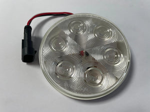 Round LED light lens with connector on white background, automotive lighting part