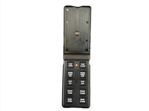 Flip-open black remote control with labeled buttons for tarp, lights, and auxiliary functions