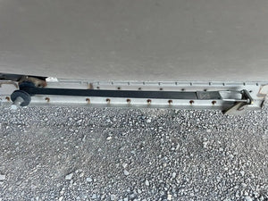 Close-up of a metal trailer latch and lock on gravel ground