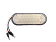 An oval Grote LED marker light with a clear lens and attached wiring