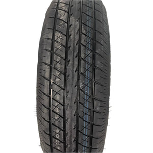 Close-up of a new black car tire with tread pattern, isolated on white background