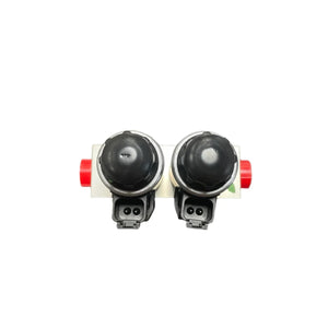 Dual black solenoid valve with red end caps on white background