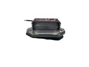 Rectangular LED license plate light with chrome housing and black wire on white background