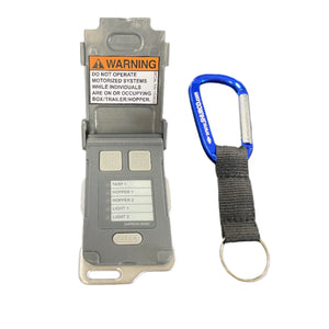 Gray remote control with warning label and blue SHURCO keychain on white background