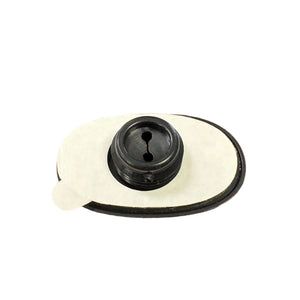 Black plastic ostomy bag adapter with adhesive backing on white background