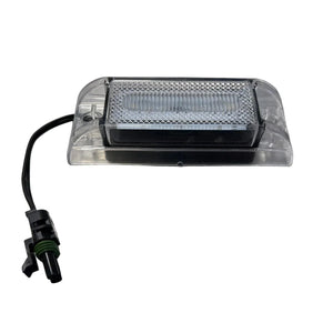Clear LED license plate light with wiring and connector on white background