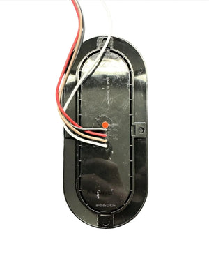 Black oval LED trailer light with exposed wiring on a white background