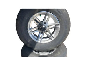 Silver five-spoke alloy truck wheel with black tire on white background